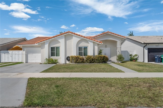 mediterranean / spanish-style home with an attached garage, a tiled roof, concrete driveway, and stucco siding