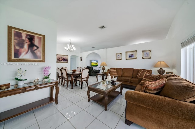 living room featuring a chandelier, light tile patterned flooring, and visible vents