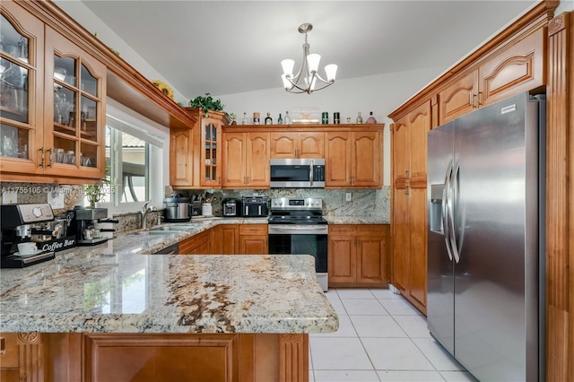 kitchen with brown cabinetry, decorative backsplash, a peninsula, stainless steel appliances, and a sink