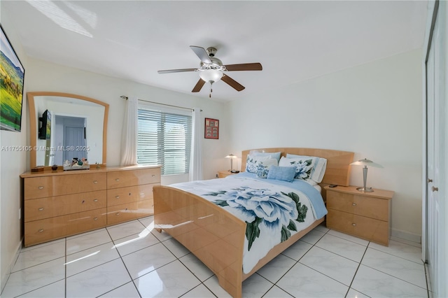 bedroom with light tile patterned floors, a ceiling fan, and baseboards