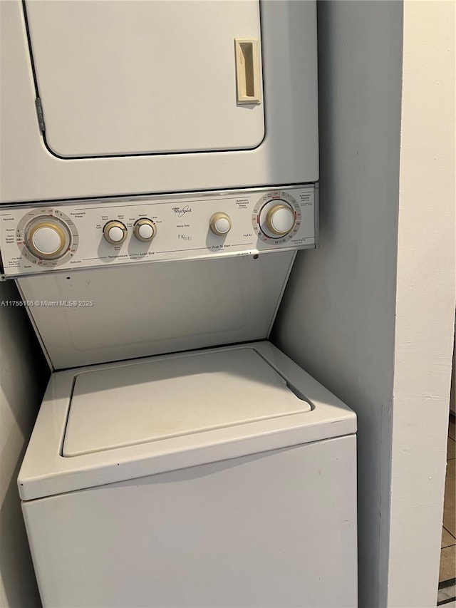 clothes washing area featuring stacked washer / dryer and laundry area