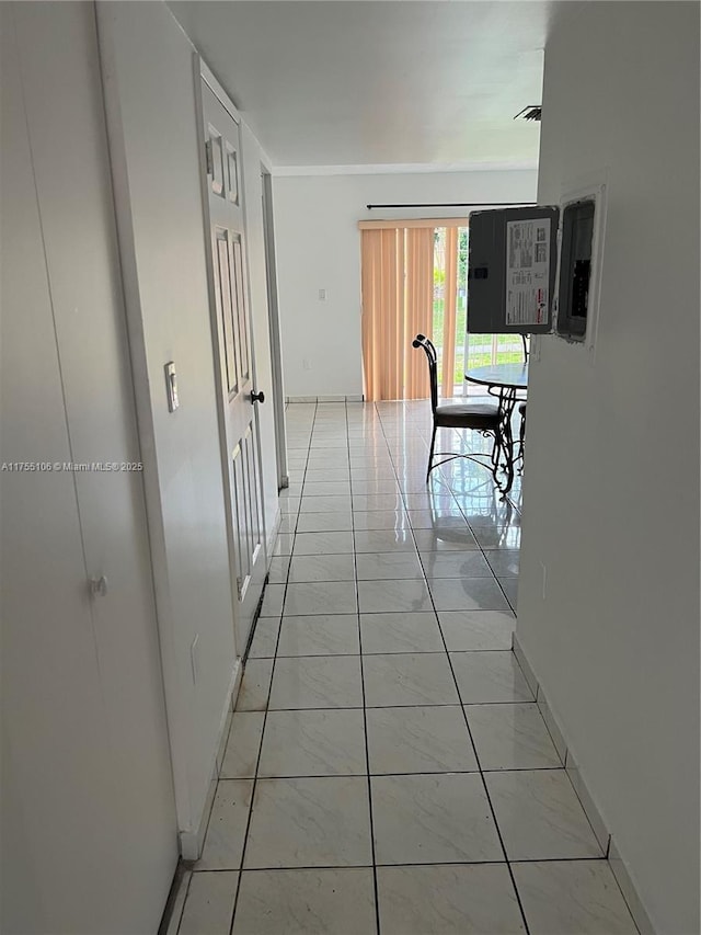 corridor with baseboards and light tile patterned floors