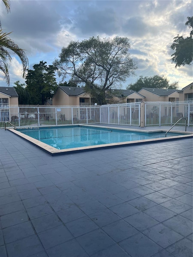 pool with a patio area and fence