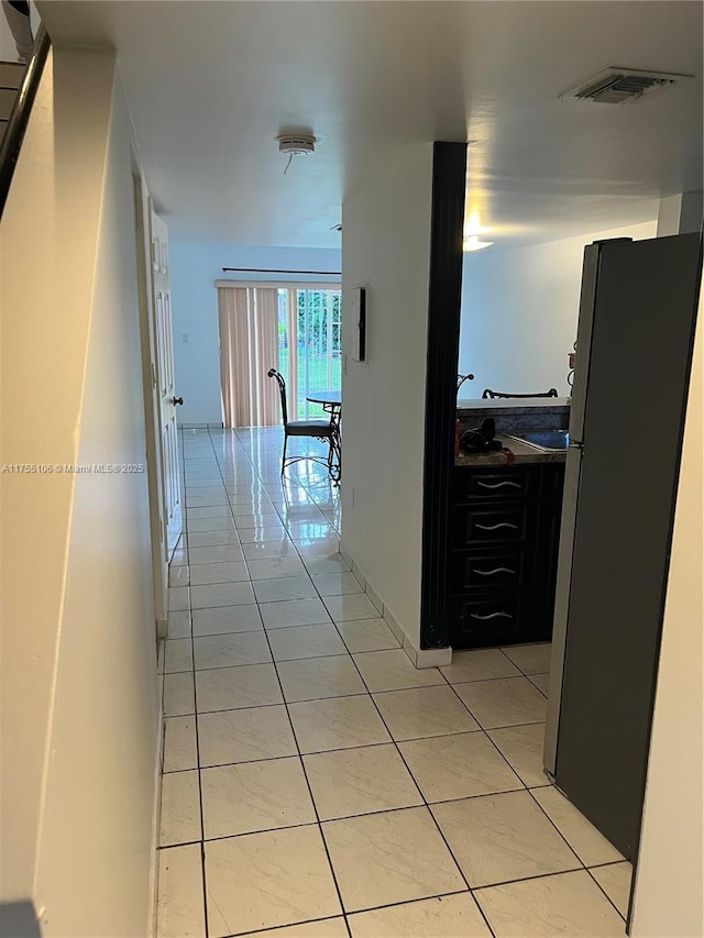 hallway with visible vents and light tile patterned floors