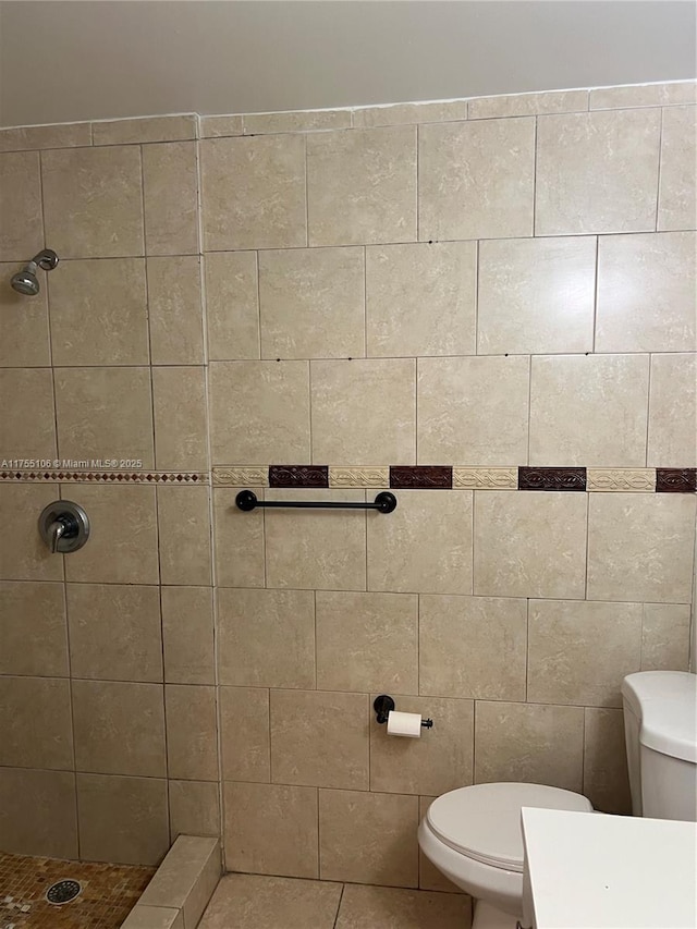 full bath featuring tiled shower and toilet