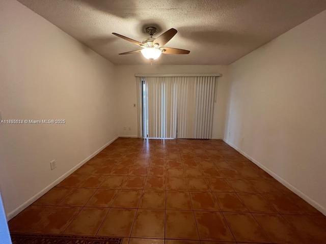 spare room featuring ceiling fan, a textured ceiling, and baseboards