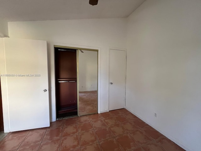 unfurnished bedroom featuring vaulted ceiling and a closet