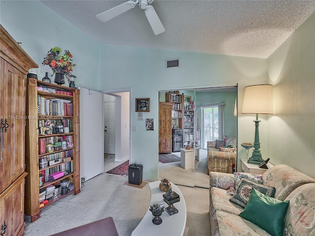 carpeted living area featuring a ceiling fan, visible vents, vaulted ceiling, and a textured ceiling