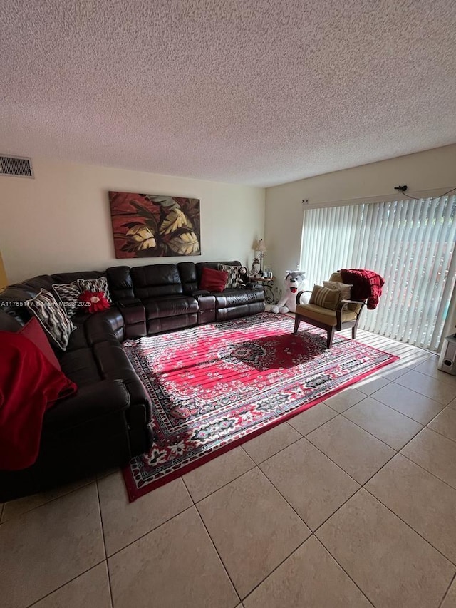 tiled living area with visible vents and a textured ceiling