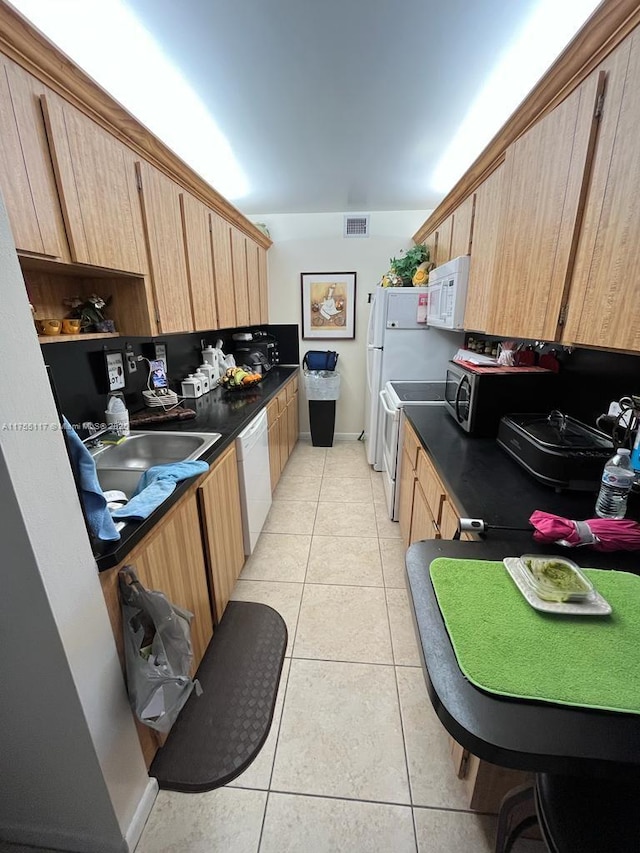 kitchen with light tile patterned floors, dark countertops, visible vents, a sink, and white appliances