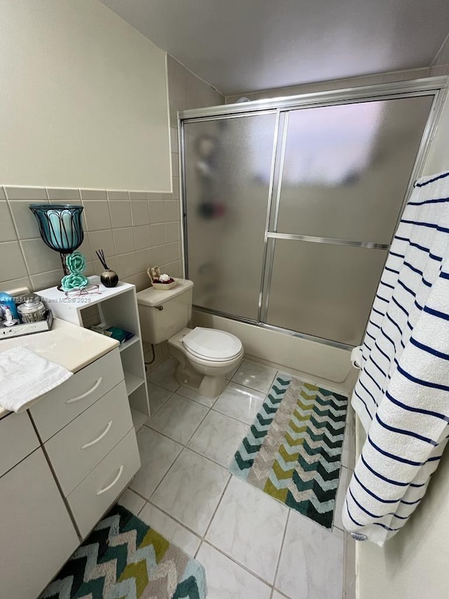 full bath with toilet, enclosed tub / shower combo, tile walls, and tile patterned floors