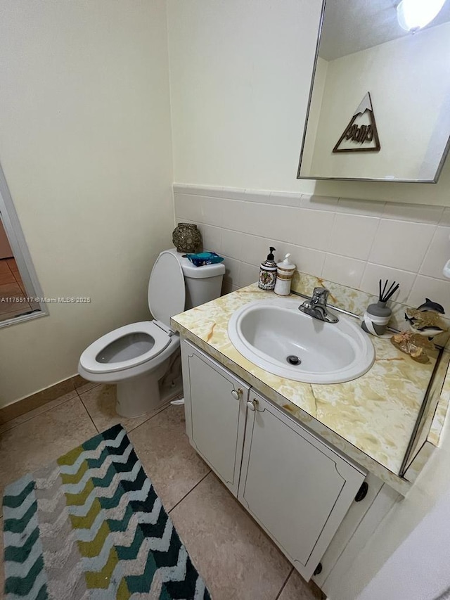 bathroom featuring tile walls, vanity, toilet, and tile patterned floors