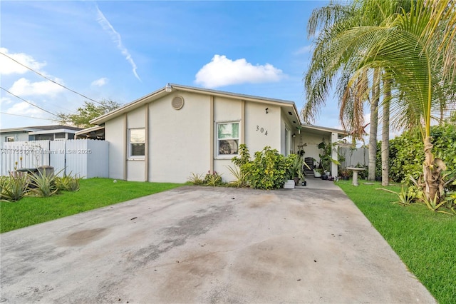 view of front facade featuring a front yard, fence, and stucco siding