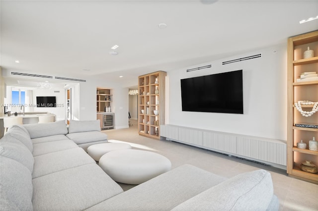 living area with built in shelves, radiator heating unit, and wine cooler