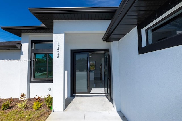 doorway to property featuring stucco siding