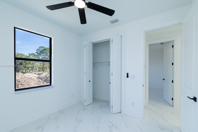 unfurnished bedroom featuring marble finish floor, a closet, visible vents, ceiling fan, and baseboards