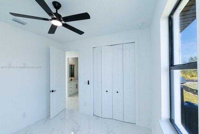 unfurnished bedroom with a closet, marble finish floor, visible vents, and baseboards