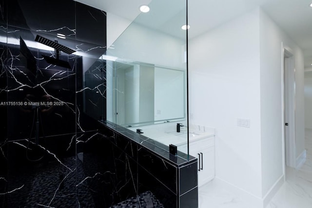 full bathroom with marble finish floor, a marble finish shower, baseboards, and vanity