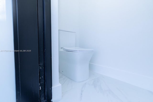 bathroom featuring marble finish floor and toilet