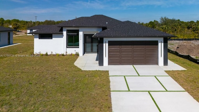 view of front facade with a front yard, driveway, an attached garage, and stucco siding