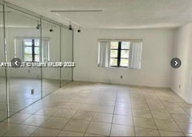 unfurnished room featuring light tile patterned floors and a wealth of natural light