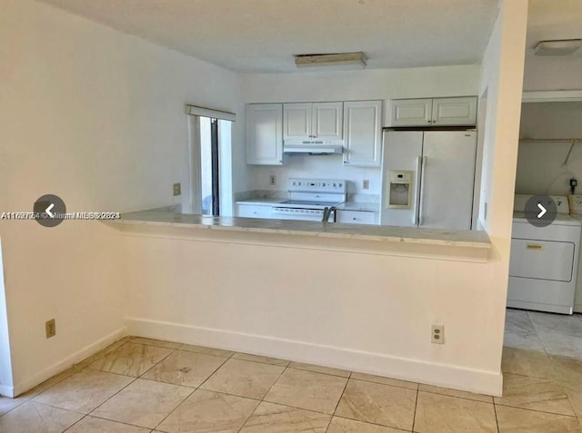 kitchen with white appliances, washing machine and clothes dryer, a peninsula, light countertops, and under cabinet range hood