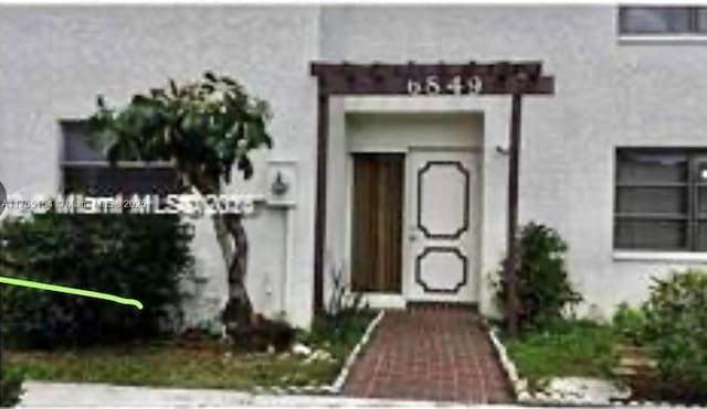 doorway to property with stucco siding