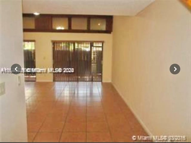 hallway featuring baseboards and tile patterned floors