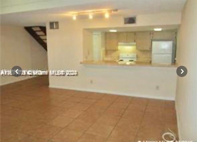 unfurnished living room with tile patterned flooring and track lighting