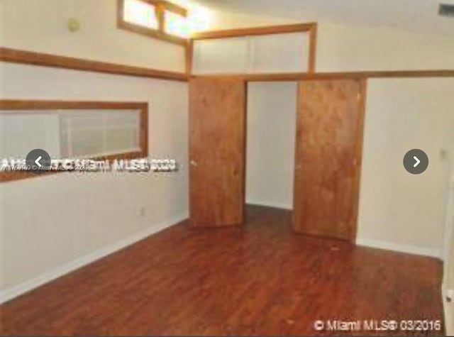 spare room featuring baseboards and wood finished floors