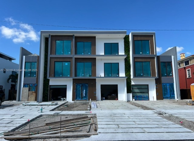 view of front of property featuring decorative driveway and stucco siding