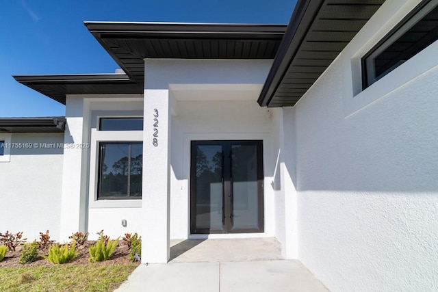 property entrance with french doors and stucco siding