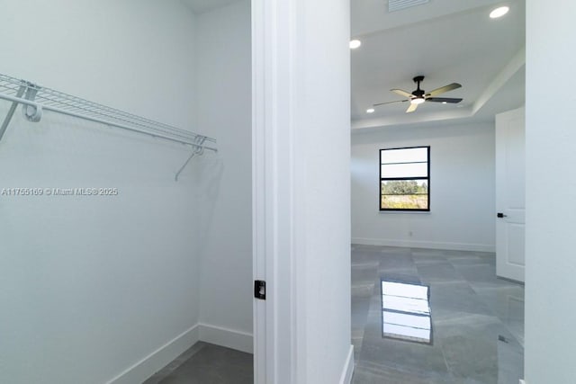 interior space with a tray ceiling and a ceiling fan