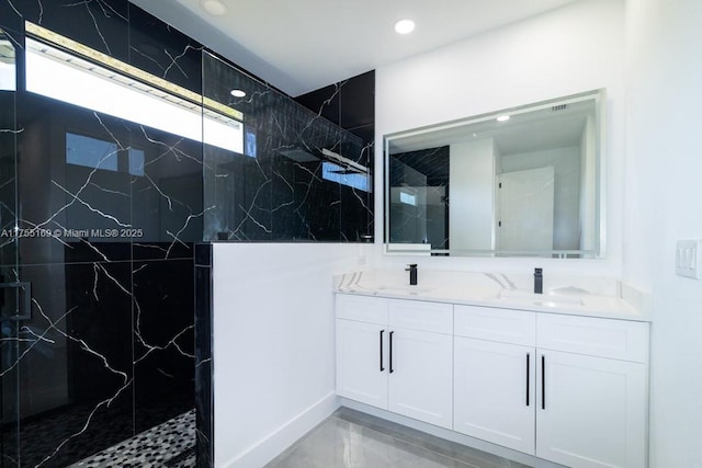 bathroom featuring recessed lighting, a sink, a marble finish shower, and double vanity