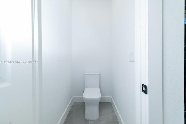 bathroom featuring toilet and baseboards