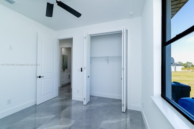 bedroom with a ceiling fan, a closet, and baseboards