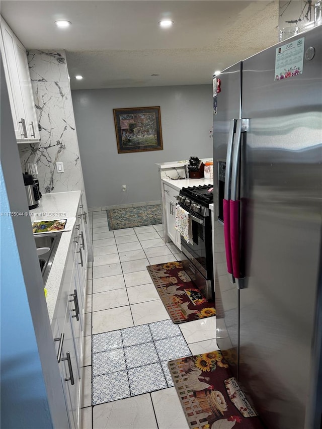 kitchen with appliances with stainless steel finishes, light countertops, white cabinetry, backsplash, and recessed lighting