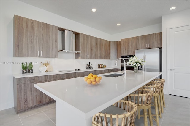 5007 Ofanto Ln, Ave Maria, FL 34142 - kitchen featuring a sink, wall chimney range hood, a kitchen breakfast bar, light tile patterned flooring, and modern cabinets