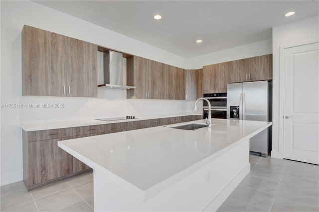 kitchen with light tile patterned floors, stainless steel appliances, a sink, wall chimney range hood, and modern cabinets