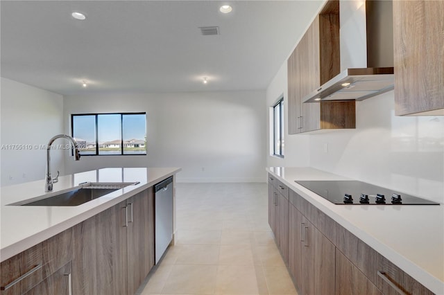 kitchen featuring wall chimney exhaust hood, modern cabinets, black electric stovetop, light countertops, and a sink