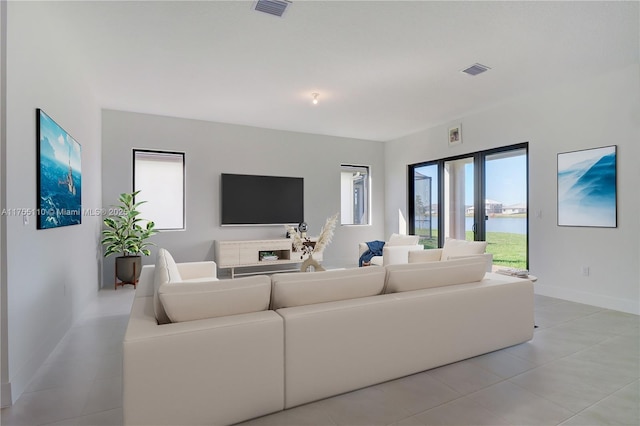 living room with baseboards, visible vents, and light tile patterned flooring