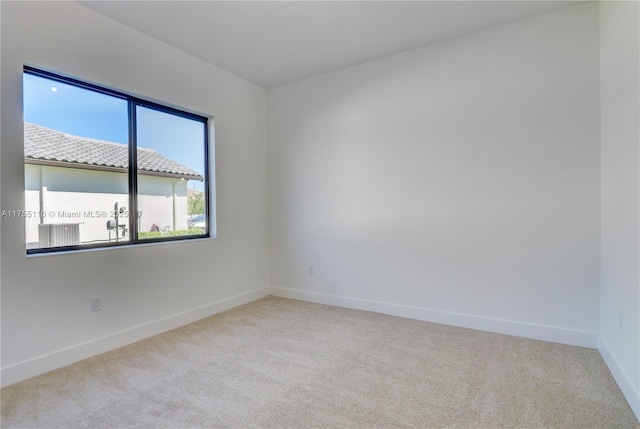 unfurnished room featuring carpet floors and baseboards