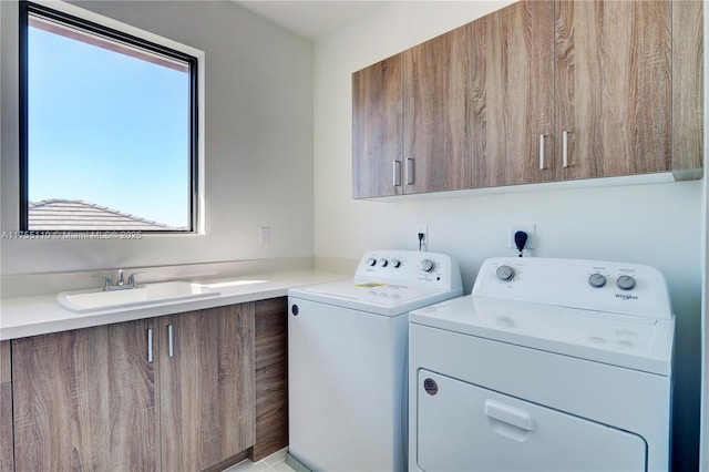 clothes washing area with washing machine and clothes dryer, a sink, and cabinet space