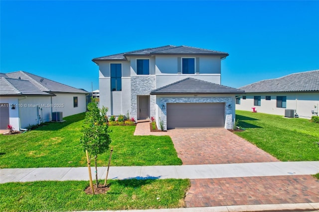 view of front of property featuring stone siding, central AC unit, a front lawn, and decorative driveway