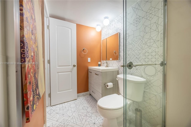 full bath with toilet, tile walls, a shower stall, tile patterned flooring, and vanity