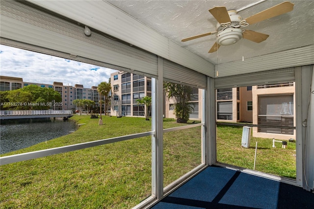 unfurnished sunroom featuring ceiling fan