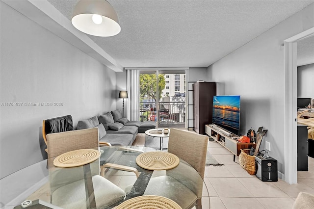 living room with light tile patterned floors, expansive windows, a textured ceiling, and baseboards