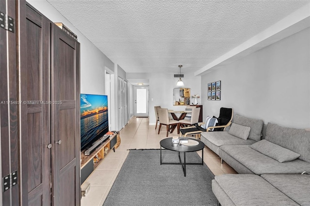 living area with a textured ceiling, light tile patterned flooring, and visible vents