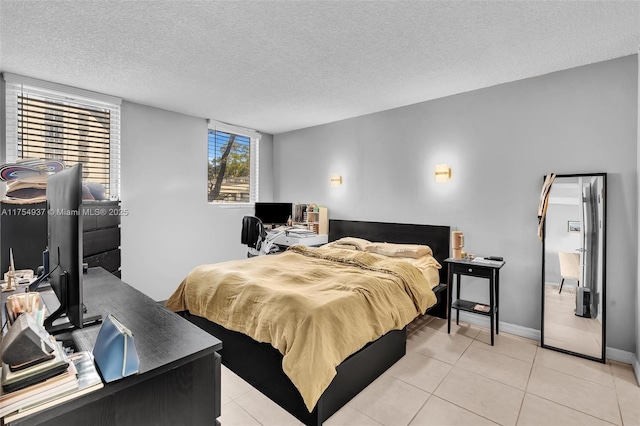 bedroom featuring light tile patterned floors, a textured ceiling, and baseboards