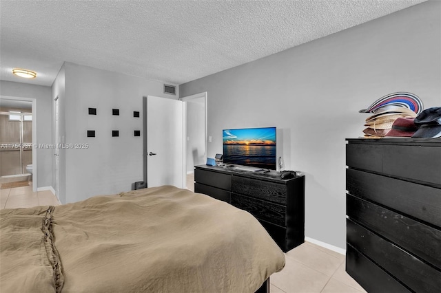 bedroom featuring visible vents, a textured ceiling, baseboards, and light tile patterned floors